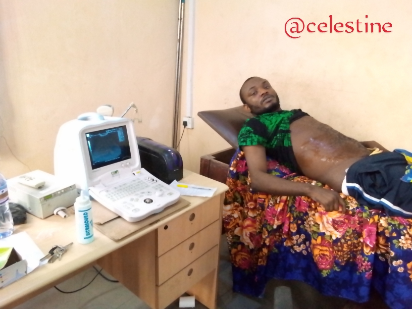 A man on an exam table at a medical clinic.