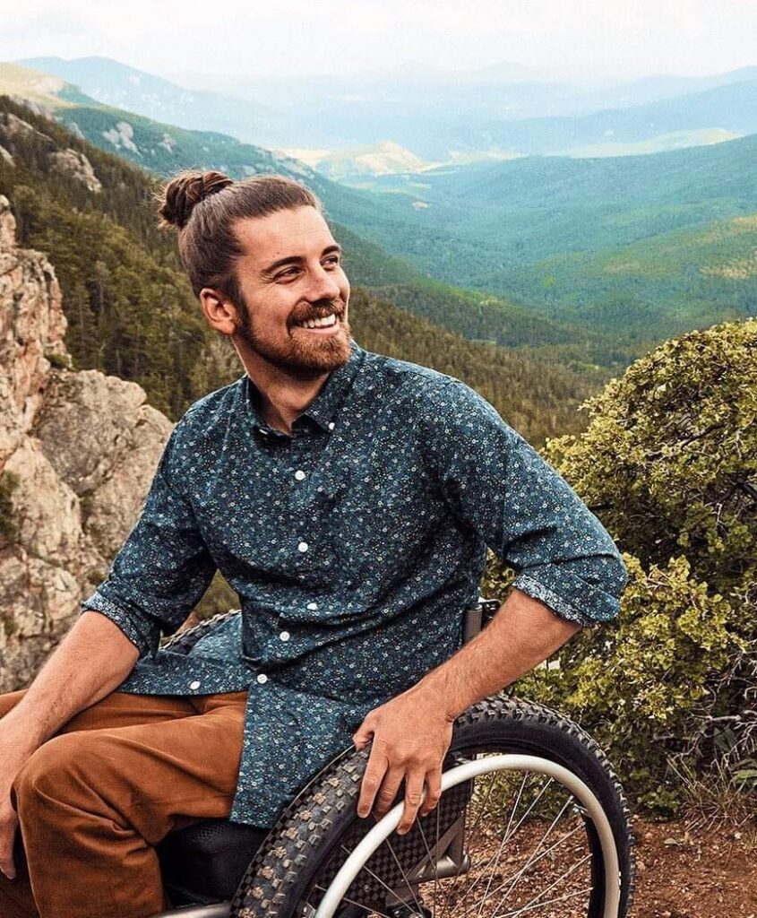 Man in wheelchair with mountains in the background.